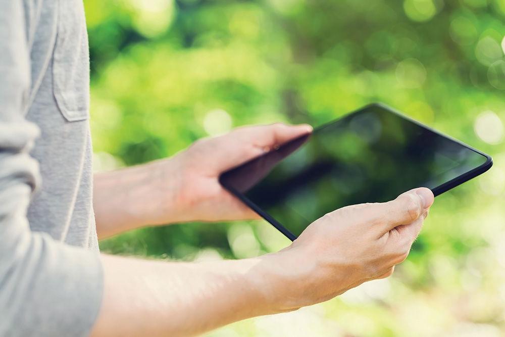 person using a tablet to control outdoor lighting